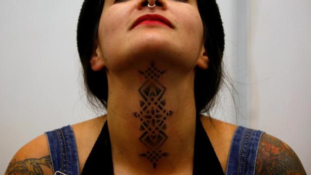 A woman shows her recently done tattoo during the Tattoo Convention. (Navesh Chitrakar / Reuters)