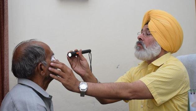 District programme manager Dr Shamsher Singh examining a patient at civil hospital in Jalandhar on Saturday.(Sikander Singh/HT Photo)