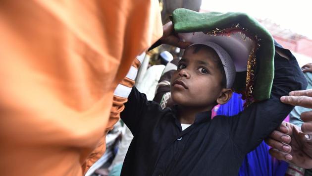 A boy holding flowers and Chaddars (Ceremonial religious drapes) at the shrine of Sufi saint Hazrat Khwaja Syed Nizamuddin Auliya during the festival. (Burhaan Kinu/HT PHOTO)