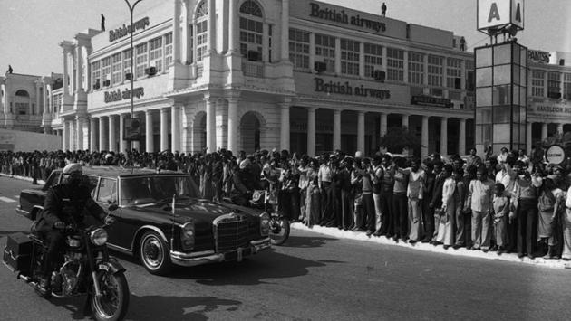 People queue up to see Queen Elizabeth II’s cavalcade crossing Connaught Place on 17 November 1983 in New Delhi. A recent report has listed Connaught Place at 9th position in the list of most expensive prime office and commercial business districts in the world. A look back at the HT archives on how it has changed over the decades. (SN Sinha/HT Photo )