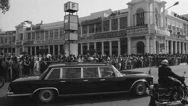 People line up to see the motorcade of Queen Elizabeth II on her visit to India at Connaught Place in 1983 outside the F Block. (sn sinha/HT Photo)
