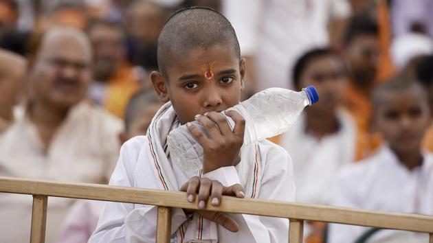 A cold water bottle provides some respite from the hot day . Enthusiasm remained high despite the heat. (Raj K Raj/HT PHOTO)