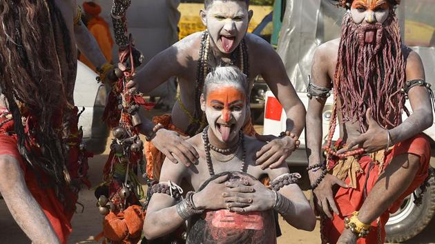 Behrupiya artist from Delhi pose around a ‘Shivling’ (a representation of a unique combination of Shiva and Shakti) . (Raj K Raj/HT PHOTO)