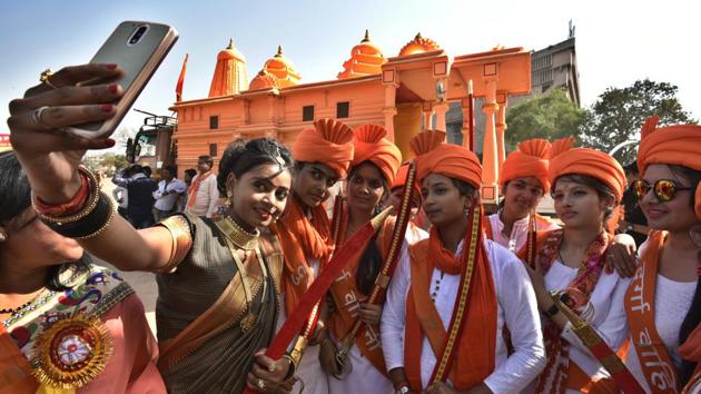 A woman dressed as Jhansi ki Rani, left, takes a selfie with members VHP women’s wing Durga Vahini in front of Ram Mandir replica. (Raj K Raj/HT PHOTO)
