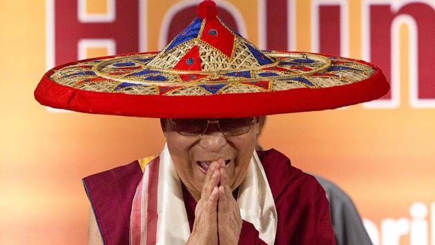 Tibetan spiritual leader Dalai Lama wears a Japi, a traditional Assamese head gear, and greets the audience during the platinum jubilee celebrations of Assam Tribune newspaper . (Anupam Nath / AP)