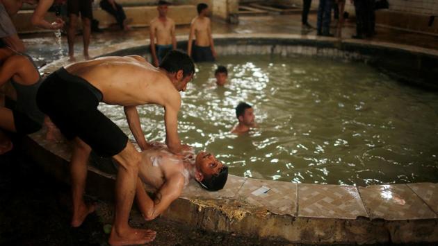Residents have been flocking back since Islamic State was expelled from the town in early November, ending the days when bathers had to wear a tunic covering them from knee to navel as part of the Sunni Muslim movement’s strict modesty code. (Suhaib Salem/REUTERS) 