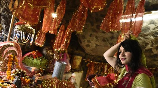 A devotees offer prayers inside a cave on Asthami, the eighth day of the festival of Navratri at Mata Mandir, in New Delhi. (Burhaan Kinu/HT PHOTO)