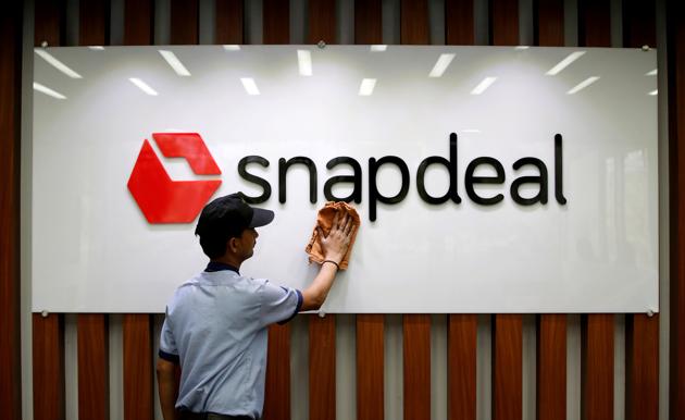 An employee cleans a Snapdeal logo at its headquarters in Gurugram on the outskirts of New Delhi.(REUTERS)