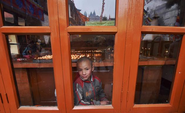 A Buddhist monk looks through a window in Thubchog Gatsel Ling Monastery ahead of a visit by exiled Tibetan spiritual leader the Dalai Lama in Bomdila. (Biju BORO / AFP)