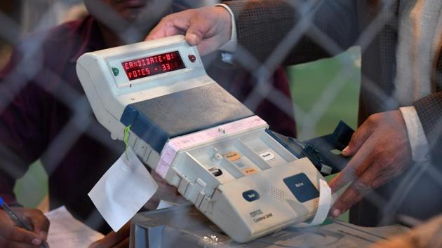 An election official shows an open Electronic Voting Machine (EVM) to political agents at a counting centre in Ghaziabad.(AFP Photo)