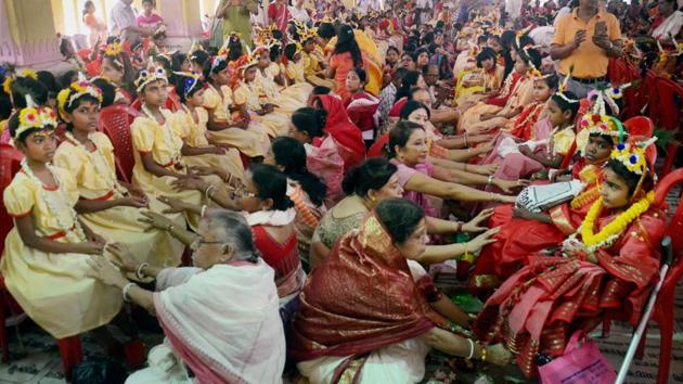 Devotees seeking blessings by touching feet of 'Kumari Kanya' (young girls) on the occasion of Ram Navami at Dakshineswar Ramkrishna Sangha Adyapeath, Dakshineswar, in Kolkata on Wednesday. More than 2000 girls participated in the Hindu festival that is observed after a nine days long fasting ritual. (PTI)