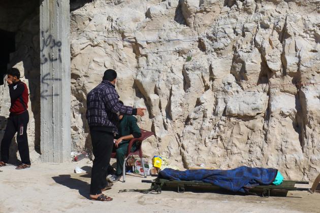 People stand near a dead body, after what rescue workers described as a suspected gas attack in the town of Khan Sheikhoun in rebel-held Idlib, Syria. (Ammar Abdullah / REUTERS)