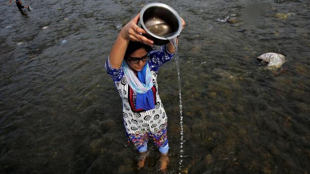 A devotee offers prayers to the Sun god in the waters of the River Tawi during the annual Hindu festival of Navratri in Jammu. (Mukesh Gupta / REUTERS)