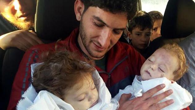 In this picture taken on Tuesday April 4, 2017, Abdel Hameed Alyousef, 29, holds his twin babies who were killed during a suspected chemical weapons attack, in Khan Sheikhoun in the northern province of Idlib, Syria. Alyousef also lost his wife, two brothers, nephews and many other family members in the attack that claimed scores of his relatives.(AP Photo)