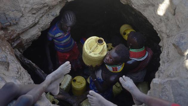 A young girl passes up a jerrycan filled with murky water trickling into a waterhole from underground rocks near Lokitaung. (TONY KARUMBA / AFP) A young girl passes up a jerrycan filled with murky water trickling into a waterhole from underground rocks near Lokitaung. (TONY KARUMBA / AFP)