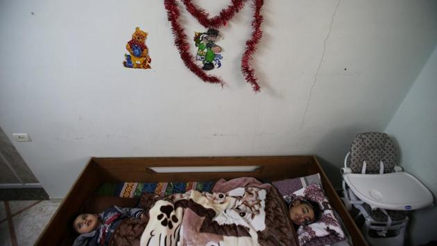 Mohammed al-Bayed (right), 13, and Amjad Bahar, 4, who suffer from cerebral palsy, lie on a a bed at Mabaret Falasteen charity in Gaza City. (Mohammed Salem/REUTERS)