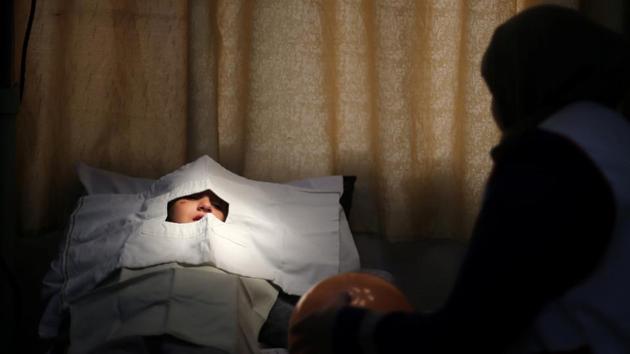 Palestinian girl Jana Al-Bodi lies on a bed before nurses remove stitches over her eye at Al Awda Hospital, a private medical facility in the northern Gaza Strip. (Mohammed Salem/REUTERS)