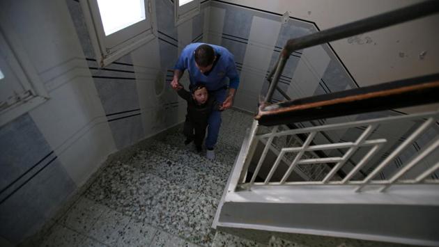 Palestinian boy Adel Shomar, 3, who suffers from cerebral palsy, is helped to walk up the stairs by a physiotherapist at Mabaret Falasteen charity. Israel says requests for medical care are reviewed on their merits in coordination with Palestinian representatives. (Mohammed Salem/REUTERS)