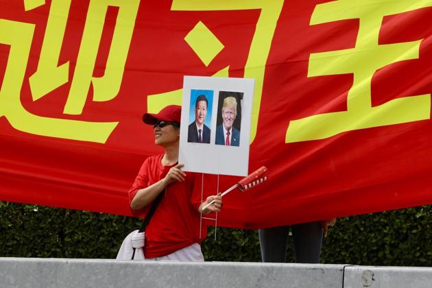 A supporter of Chinese President Xi Jinping stands on the street outside the Eau Palm Beach. Analysts believe any military action would likely provoke severe North Korean retaliation and massive casualties in South Korea and Japan and among U.S. troops stationed there. (AP)