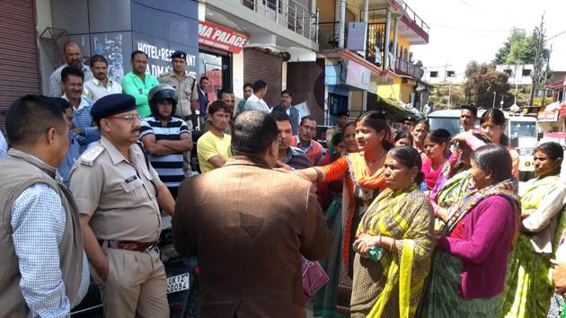 Local administration and excise department officials speak to protesters at Pauri on Sunday.(HT Photo)