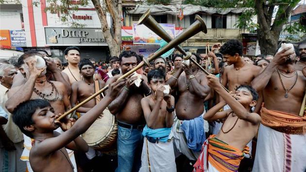 Devotees playing instruments during the annual Panguni celebrations of the Mylapore Sri Kapaleeswarar Temple when a chariot carrying the idol of Lord Shiva is taken out, in Chennai on Saturday. (PTI)