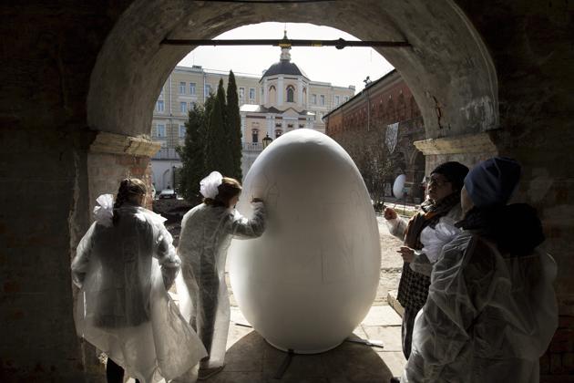 Children paint a huge symbolic egg in preparation for Orthodox Easter, after the Palm Sunday mass at the St. Peter's Cathedral in the High-Petrovsky monastery in Moscow, Russia. (AP)