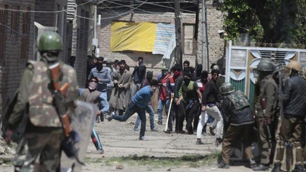 Kashmiri youth throw stones at paramilitary soldiers during clashes outside a polling station at Soura on the outskirts of Srinagar.(Waseem Andrabi/Hindustan Times)