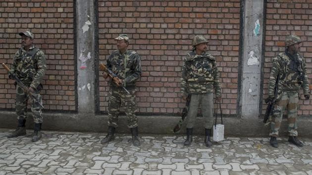 Paramilitary soldiers stands guard during distribution of election material outside a local college in Srinagar . (Dar Yasin / AP)