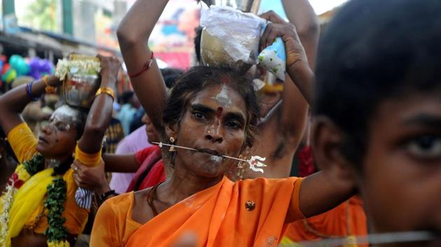 Devotees make offerings through sacrificial feats they believe will keep them away from evil spirits. (ARUN SANKAR / AFP)