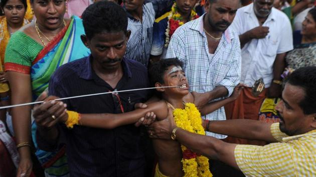An Indian child has his cheeks pierced with a metal skewer as he takes part in a procession to mark the Panguni Uthiram festival in Chennai. (ARUN SANKAR / AFP)