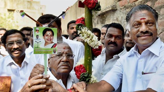 AIADMK leader and former Tamil Nadu chief minister O Panneerselvam presents the party symbol (electric pole) to the RK Nagar bypoll candidate E Madhusudhanan in Chennai on March 26, 2017.(PTI Photo)