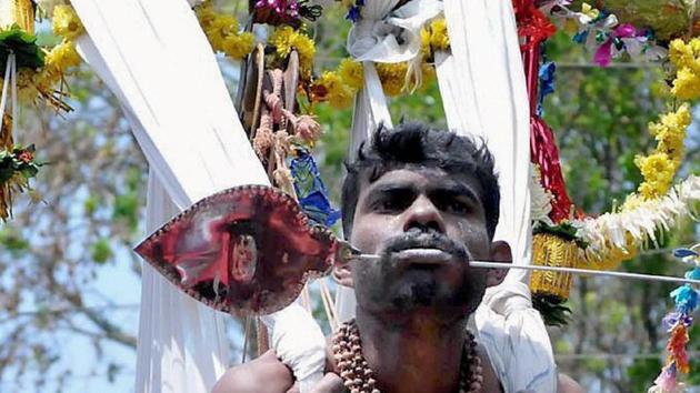 A Devotee pierced his mouth with iron rod as an offering on the occasion of Panguni Uthiram at Mallandur near Chikmagalur in Karnataka. (PTI)