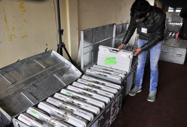 A government employee takes out electronic voting machines at a local school in Srinagar. (Waseem Andrabi / HT Photo)