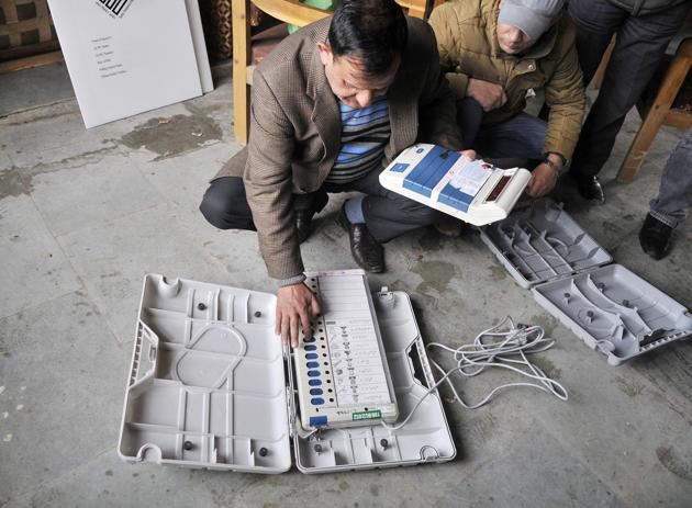 A Kashmir election officer,checks electronic voting machines during a distribution of election material at a local school in Srinagar. (Waseem Andrabi / HT Photo)