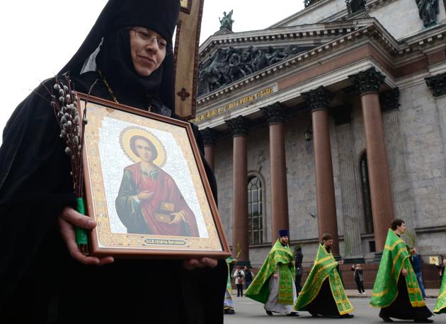 Russian Orthodox nun carries an icon during the Palm Sunday procession outside the Saint Isaac's Cathedral in Saint Petersburg, on April 9, 2017. (OLGA MALTSEVA / AFP)