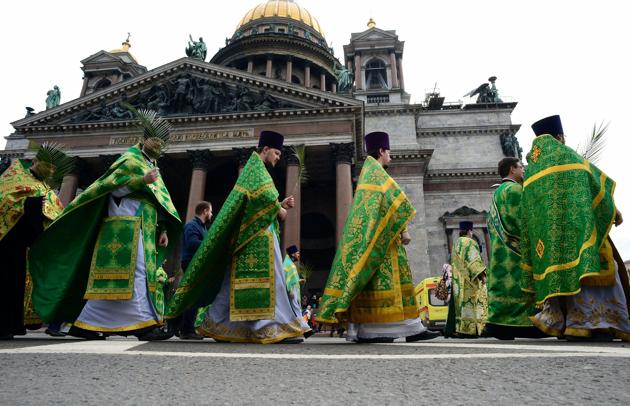 Russian Orthodox priests carry palm branches during the Palm Sunday procession outside the Saint Isaac's Cathedral in Saint Petersburg. (OLGA MALTSEVA / AFP)