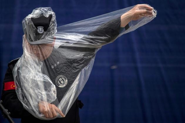 A security man puts on his rain jacket at the paddock in Shanghai on April 6, 2017, ahead of the Formula One Chinese Grand Prix. (Johannes EISELE / AFP)