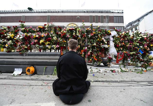A man pays his respects at a makeshift memorial near the site where a truck slammed into a crowd yesterday outside a busy department store, in central Stockholm, on April 8, 2017. (Jonathan NACKSTRAND / AFP)