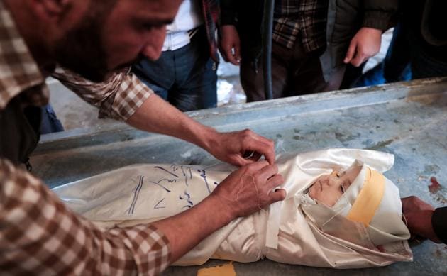 A Syrian wraps the burial shrowd of one-year-old infant Amira, whose body lies in a make-shift morgue, after she died in a reported air strike on the rebel-held town of Douma, on the eastern outskirts of the Syrian capital Damascus, on April 7, 2017. (Abd Doumany / AFP)