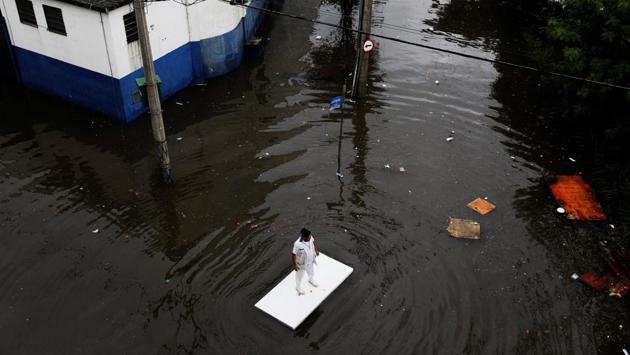 A worker uses a table to move along a flooded street after heavy rainfall in Sao Paulo, Brazil April 7, 2017. (REUTERS)
