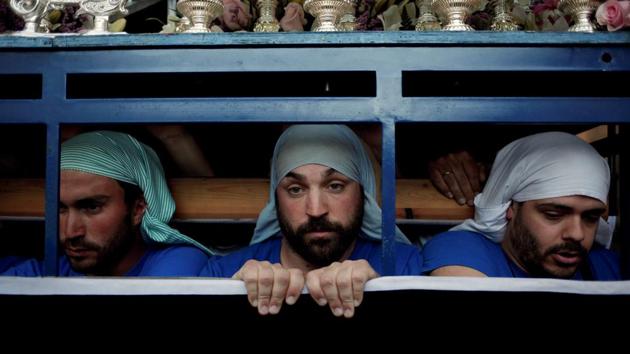 Costaleros of the Los Gitanos brotherhood, (men who carry a float bearing the statue of the Virgin Mary), known traditionally as "paso", take part in a procession during the Holy Week in Ronda. (Jon Nazca/REUTERS)