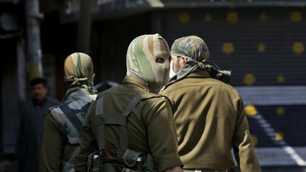 Masked policemen patrol at a closed market during a strike in Srinagar on Monday.(AP Photo)