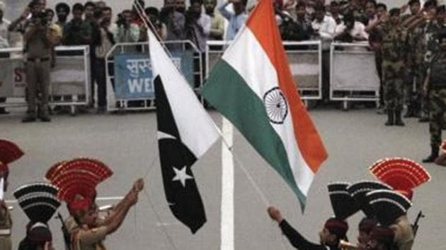 Pakistani rangers (in black uniforms) and Indian Border Security Force (BSF) officers lower the national flags during a daily parade at the Wagah border. Pakistan has charged Kulbhushan Jadhav for his alleged involvement in espionage and sabotage against Pakistan as a Research and Analysis Wing (R&AW) agent. He was arrested on March 3 last year in Balochistan.(Reuters File Photo)