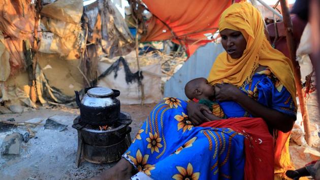 Zeinab's sister Habiba, 29, feeds her baby as she sits beside a teapot at a camp for internally displaced people from drought hit areas in Dollow. The exchange, is typical of the choices facing Somali families after two years of poor rains. Crops withered and the white bones of livestock are scattered across the Horn of Africa nation. (Zohra Bensemra/REUTERS)