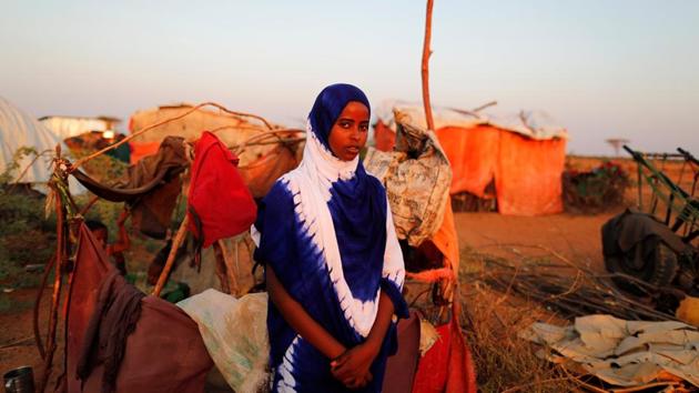 Zeinab, 14, poses for a photograph beside her shelter at a camp. The disaster is part of an arc of hunger and violence threatening 20 million people as it stretches across Africa into the Middle East. (Zohra Bensemra/REUTERS)