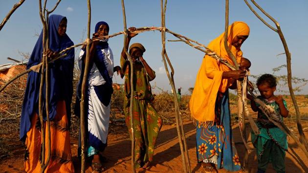 Zeinab (2nd L), 14, helps her mother Abdir (L) and her sisters Farhiya and Habiba (R) to build a new shelter at a camp. Once the family had cows and goats and three donkeys that they hired out with carts for transport. But the animals died around them and Zeinab became their only hope of escape. (Zohra Bensemra/REUTERS)