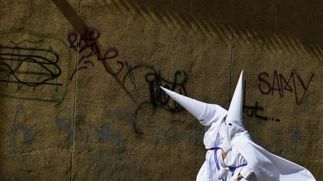 Penitents of the 'La Paz' brotherhood walk in Sevilla during the Holy Week. (Cristina Quicler/AFP)