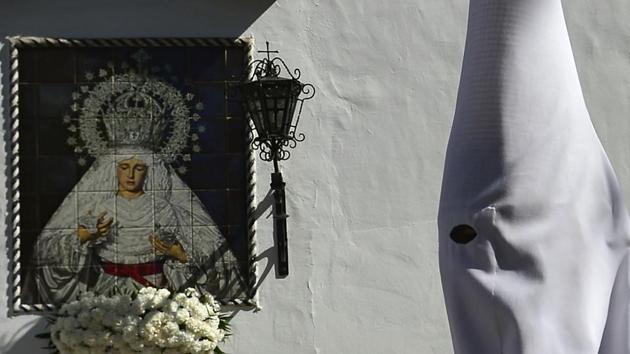 A penitent of the 'La Paz' brotherhood walks to his church during the Holy Week. (Cristina Quicler/AFP)