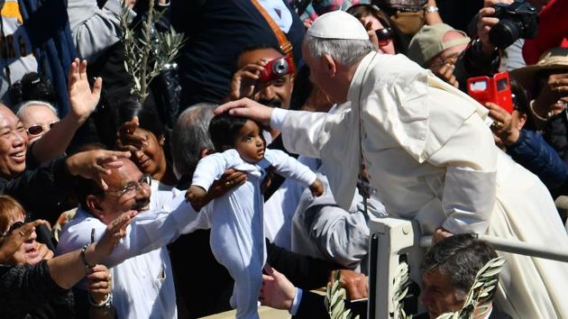 Pope Francis blesses a child at the end of the Palm Sunday mass. (Vincenzo Pinto/AFP)