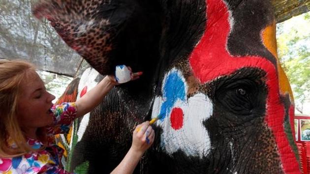 A volunteer paints an elephant in celebration of the Songkran water festival.